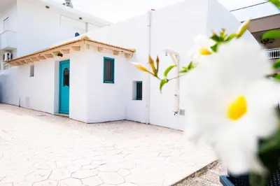 a white building with a blue door at Stefanis Relis House in Archangelos
