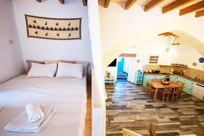 a bedroom and a kitchen with a bed and a table at Stefanis Relis House in Archangelos