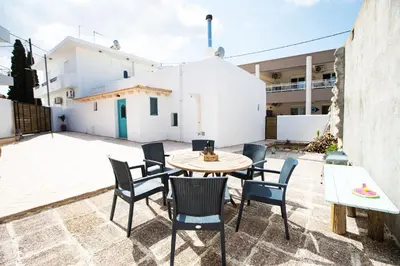a patio with a table and chairs and a building at Stefanis Relis House in Archangelos