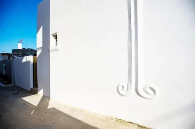 a white wall next to a white building at Stefanis Relis House in Archangelos