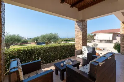 a patio with chairs and tables on a patio at Cielo Blu villa in Soroni