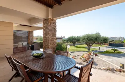 a patio with a wooden table and chairs at Cielo Blu villa in Soroni