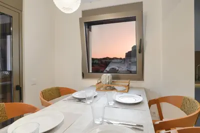 a dining room with a table and chairs and a window at Mylos Luxury Escape Villa in Faliraki