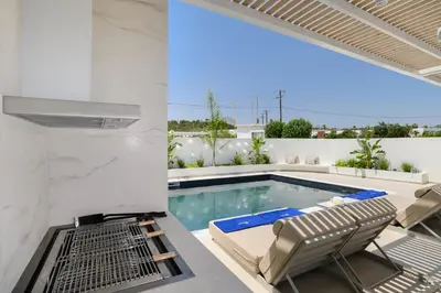 a swimming pool with two chairs and a table on a patio at Mylos Luxury Escape Villa in Faliraki