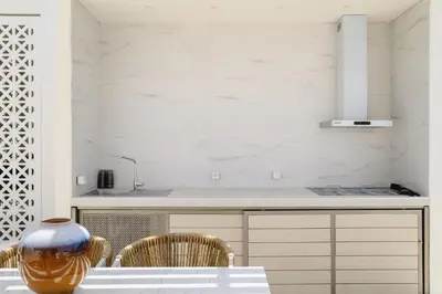 a kitchen with a table with chairs and a vase at Mylos Luxury Escape Villa in Faliraki