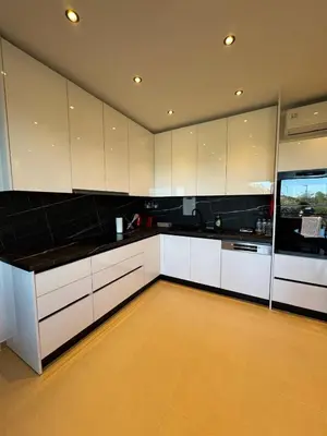a kitchen with white cabinets and black counter tops at Lihi's Sea View in Rhodes in Rhodes Town
