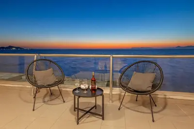 two chairs and a table with a bottle of wine at Lihi's Sea View in Rhodes in Rhodes Town
