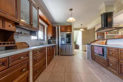 a large kitchen with wooden cabinets and a stainless steel refrigerator at Onda Vista Luxury Villa in Kremasti