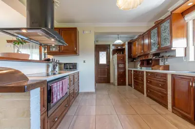 a large kitchen with wooden cabinets and a large island at Onda Vista Luxury Villa in Kremasti