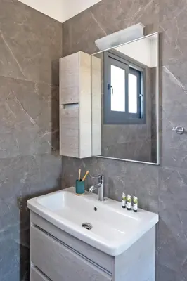 a bathroom with a sink and a mirror at Lotus Luxury Apartments in Kremasti