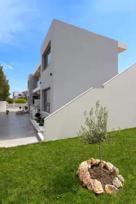 a house with a small tree in the yard at Lotus Luxury Apartments in Kremasti