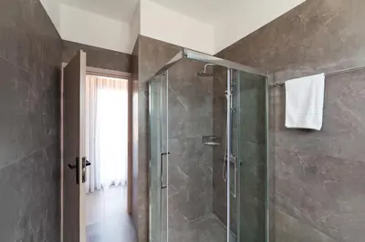 a bathroom with a shower with a glass door at Lotus Luxury Apartments in Kremasti