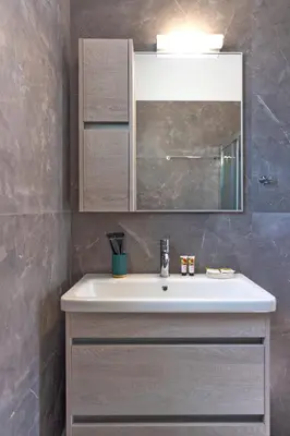 a bathroom with a white sink and a mirror at Lotus Luxury Apartments in Kremasti