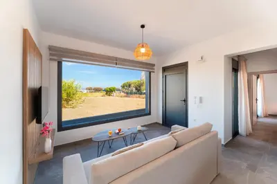 a living room with a couch and a large window at Lotus Luxury Apartments in Kremasti