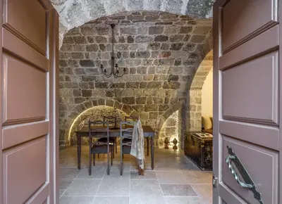 a dining room with a table and a brick wall at Spanish Knights Inn in Rhodes Town