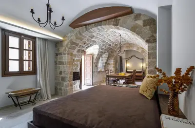 a bedroom with a large bed with a stone wall at Spanish Knights Inn in Rhodes Town
