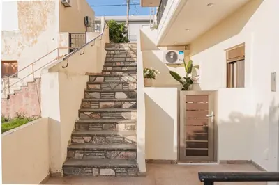 a staircase leading up to a house with a door at Cozy Guesthouse in Koskinou