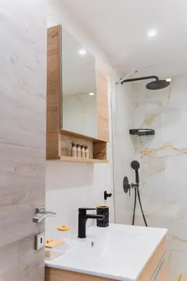 a bathroom with a sink and a mirror at Cozy Guesthouse in Koskinou