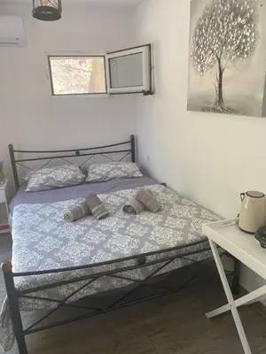 a bedroom with a bed with two slippers on it at Lilly's Cosy Studio in Rhodes Town