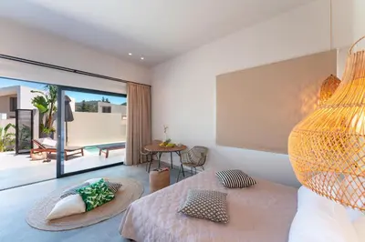 a bedroom with a bed and a view of a patio at Afesou Suites in Ialyssos