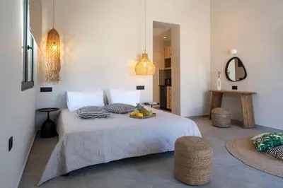 a bedroom with a bed with a bowl of fruit on it at Afesou Suites in Ialyssos