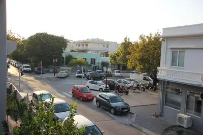 a city street with cars parked in a parking lot at Micasa Shiny Apartment in Rhodes Town