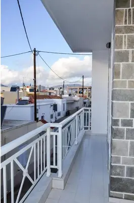 a balcony with a white railing and a brick building at Arco In Pietra in Apolakkiá