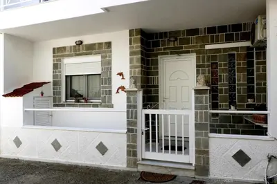 a brick wall with a white door and a mirror at Arco In Pietra in Apolakkiá