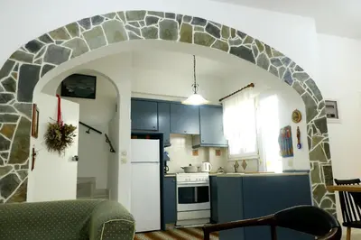 a kitchen with an archway in the middle of a room at Arco In Pietra in Apolakkiá