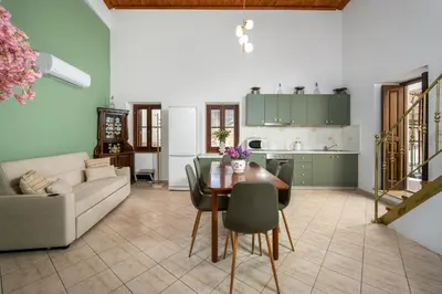 a kitchen and living room with a table and a couch at Aelius Apartments in Symi