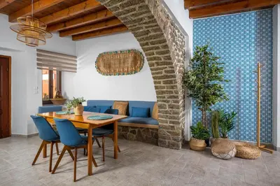 a dining room with a table and blue chairs at Aelius Apartments in Symi