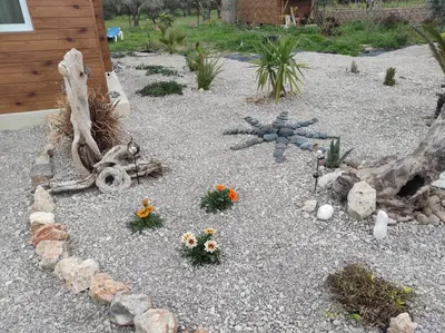 a garden with flowers and rocks and a log at Mountain View Bungalows Dimilia in Phanaes