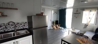 a kitchen with a refrigerator and a living room at Mountain View Bungalows Dimilia in Phanaes