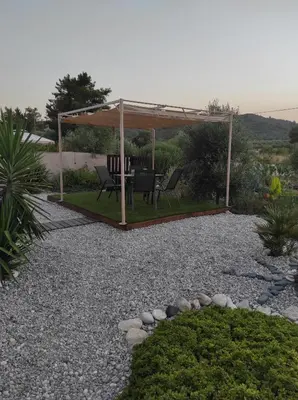 a gazebo with a table and chairs in a garden at Mountain View Bungalows Dimilia in Phanaes
