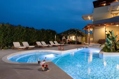 a swimming pool with lounge chairs next to a house at Excelencia New Villa with Artistic Pool & Sea View in Asgourou