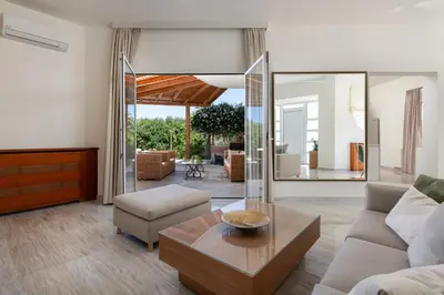 a living room with a couch and a table at Excelencia New Villa with Artistic Pool & Sea View in Asgourou