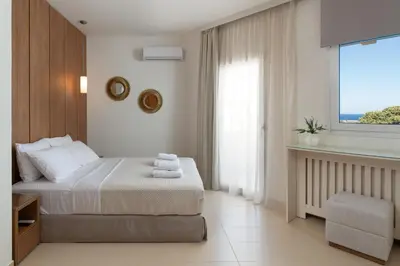a hotel room with a bed and a window at Excelencia New Villa with Artistic Pool & Sea View in Asgourou