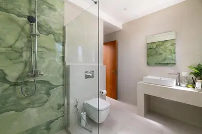 a bathroom with a shower with a toilet and a sink at Excelencia New Villa with Artistic Pool & Sea View in Asgourou