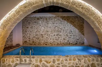 a large pool in a stone wall with an arch at Villa Gemma 2 next to Faliraki in Kalithies