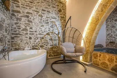a bathroom with a chair next to a bath tub at Villa Gemma 2 next to Faliraki in Kalithies