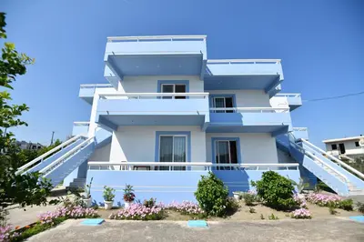 a white house with blue steps and flowers at Blue Serenity Apartment 5 in Ialyssos
