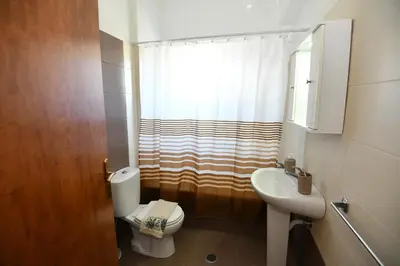 a bathroom with a white toilet and a sink at Blue Serenity Apartment 5 in Ialyssos