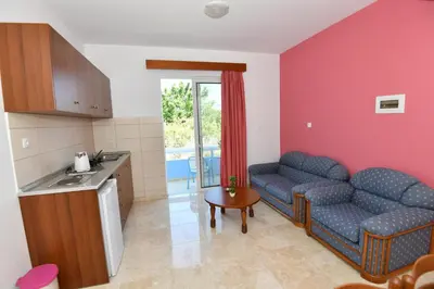 a kitchen and a living room with a couch and a table at Blue Serenity Apartment 5 in Ialyssos