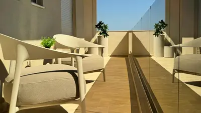 a balcony with white chairs and tables on a building at ARYVE Boutique Villa mit Akropolis- und Meerblick, Infinity-Pool und Designer-Interieur in Malona Village