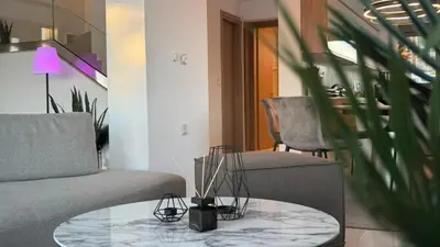 a living room with a couch and a glass table at ARYVE Boutique Villa mit Akropolis- und Meerblick, Infinity-Pool und Designer-Interieur in Malona Village