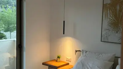 a room with a bed and a table next to a window at ARYVE Boutique Villa mit Akropolis- und Meerblick, Infinity-Pool und Designer-Interieur in Malona Village