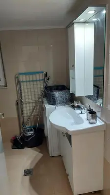 a bathroom with a white sink and a mirror at George & Chrysi Apart in Kremasti