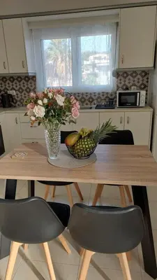 a table with a bowl of fruit and a vase of flowers at George & Chrysi Apart in Kremasti