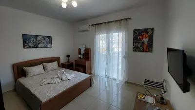 a bedroom with a bed with a television and a window at George & Chrysi Apart in Kremasti