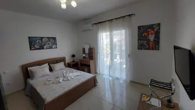 a bedroom with a bed with a television and a window at George & Chrysi Apart in Kremasti